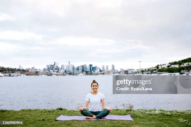 mujer estirando y meditando por seattle waterfront - condado de king fotografías e imágenes de stock