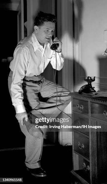 American actor, John Garfield , talks on the phone while changing clothes circa May, 1947 in New York, New York.