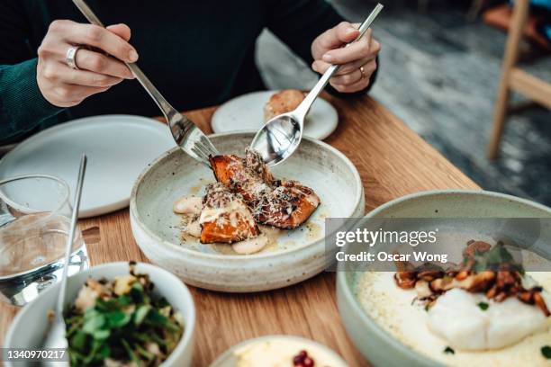 close-up shot of young woman enjoying a vegetarian meal at restaurant - fooding imagens e fotografias de stock