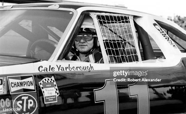 Driver Cale Yarborough sits in his car prior to a practice session for the 1980 Daytona 500 at the Daytona International Speedway on February 16,...