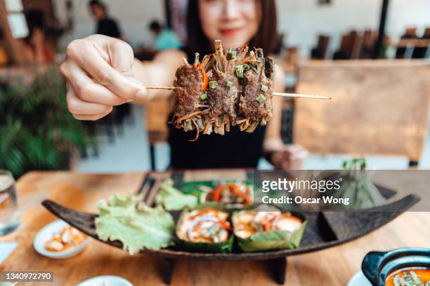 young woman sharing authentic thai food in local thai street food stall - food stall bildbanksfoton och bilder