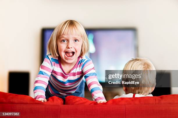 bouncy little girl jumps excitedly on the couch - adhd stockfoto's en -beelden