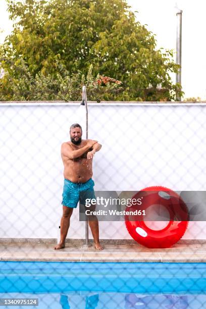 mature man taking shower at poolside - chubby swimsuit stock pictures, royalty-free photos & images