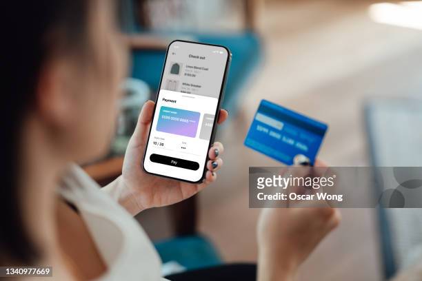 young woman doing online shopping on smartphone - pay with phone stock-fotos und bilder
