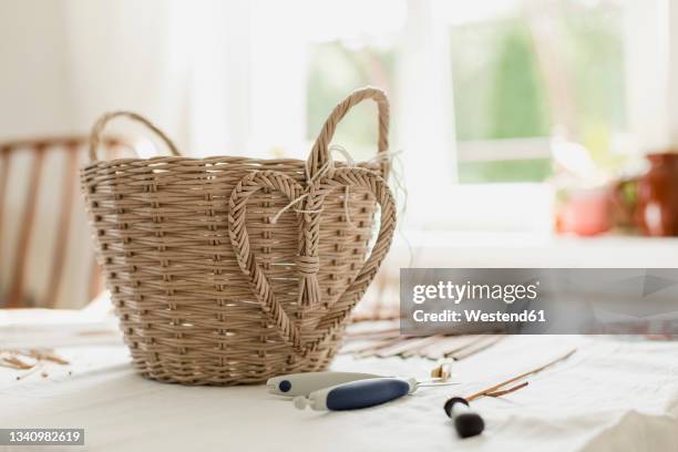 wicker basket of paper vine on table in living room - wicker heart stock pictures, royalty-free photos & images