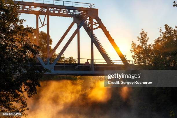 the railway bridge in rays of the rising sun - truss bridge stock pictures, royalty-free photos & images