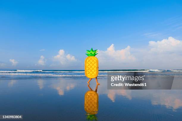 woman with pineapple float walking at beach - inflatable stock pictures, royalty-free photos & images