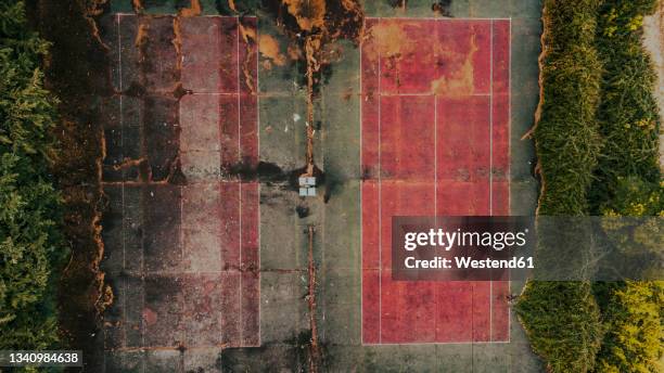 aerial view of empty abandoned tennis courts - schlechter zustand stock-fotos und bilder