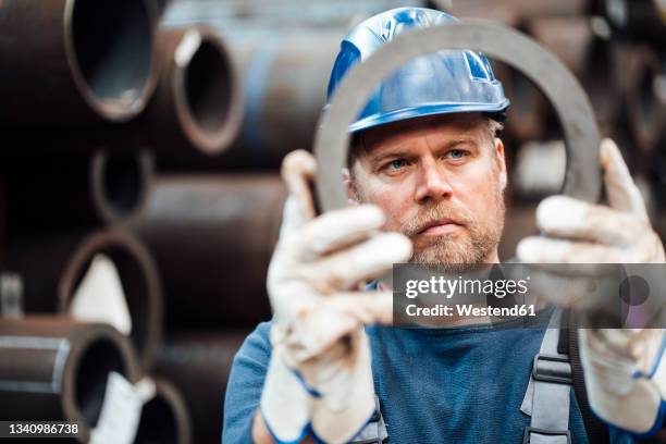 male inspector checking circle shape steel equipment in warehouse - indústria metalúrgica - fotografias e filmes do acervo