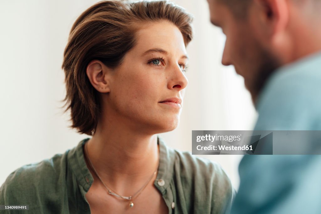 Suspicious woman looking at man