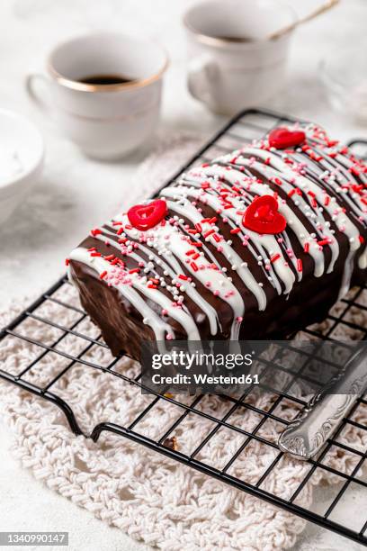 glazed chocolate cake with sugar sprinkles and heart shaped decorations - glazed food stock pictures, royalty-free photos & images