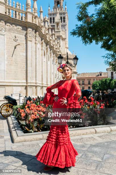female flamenco artist with hands on hip standing at plaza del triunfo, seville, spain - flamencos stock-fotos und bilder