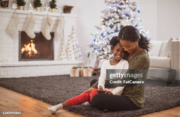 mother and daughter hug on christmas - women wearing black stockings stock pictures, royalty-free photos & images