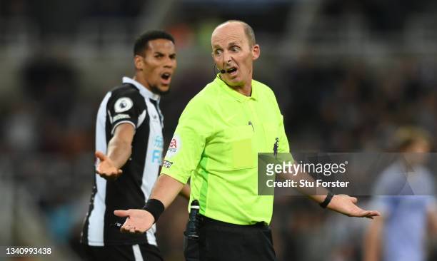 Referee Mike Dean reacts as Isaac Hayden looks on during the Premier League match between Newcastle United and Leeds United at St. James Park on...