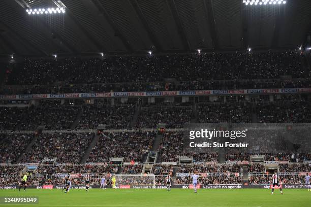 Fans from both teams join to pay homage to Gary Speed by putting their lights on their phones during the Premier League match between Newcastle...