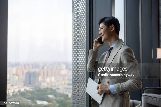 asian businessmen using mobile phones - belt stockfoto's en -beelden