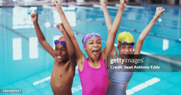 porträt einer gruppe kleiner kinder, die während einer schwimmstunde in einem hallenbad jubeln - child swimming stock-fotos und bilder