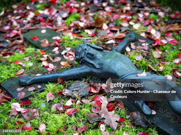 old bronze crucifix and dead leaves in a cemetery in brussels - empty tomb jesus fotografías e imágenes de stock