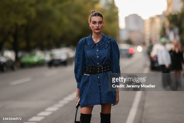 Celine Bethmann wearing a jeans dress, a black bag and black overknee boots on September 13, 2021 in Berlin, Germany.