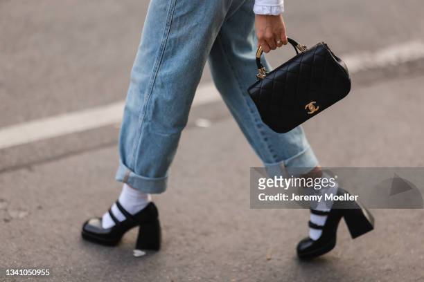 Fashion Week Guest wearing a jeans overall, a black chanel bag and black shoes on September 13, 2021 in Berlin, Germany.