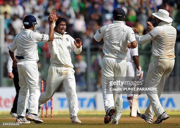 Indian bowler Pragyan Ojha celebrates with teammates after taking wicket of West Indies batsman Darren Bravo during fifth day play of the third Test...