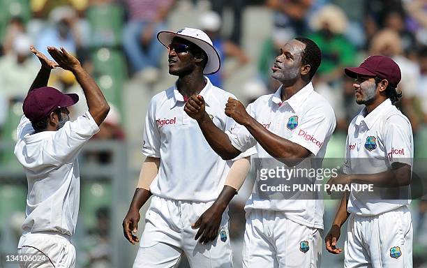 West Indies bowler Marlon Samuels celebrates with teammates captain Darren Sammy , Devendra Bishoo and Adrian Barath after dismissing Indian batsman...