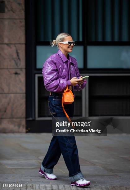 Guest is seen wearing purple cropped jacket, orange Balenciaga bag, dark denim jeans outside Rixo during London Fashion Week September 2021 on...