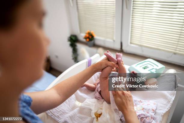 mother changing the baby's diaper - stool stockfoto's en -beelden