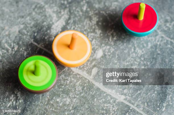 spinning top vibrant color infidelity concepts - spinning top stock pictures, royalty-free photos & images