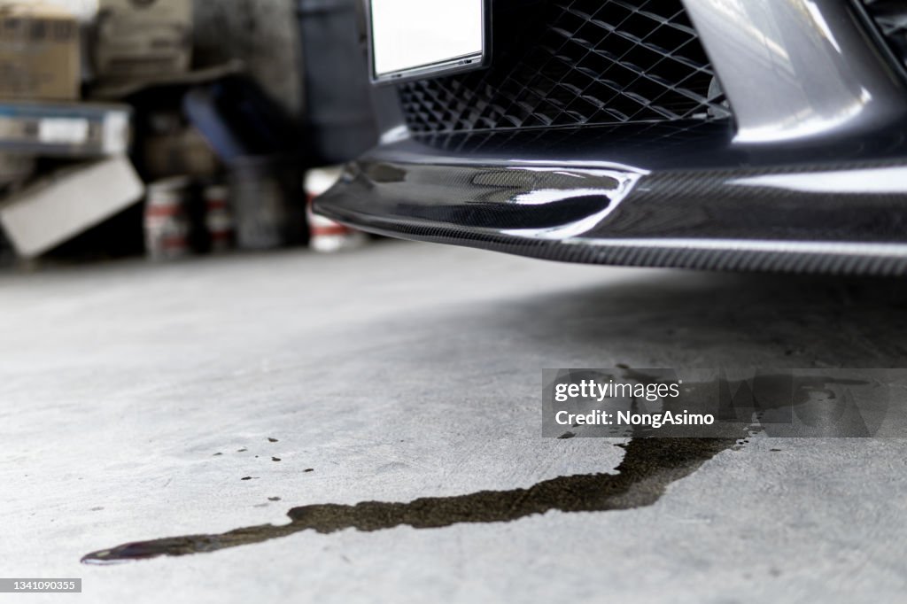 Manchas de aceite del motor del automóvil Fuga debajo del automóvil cuando el automóvil está estacionado en el concepto de foto de servicio de carretera para verificación y mantenimiento
