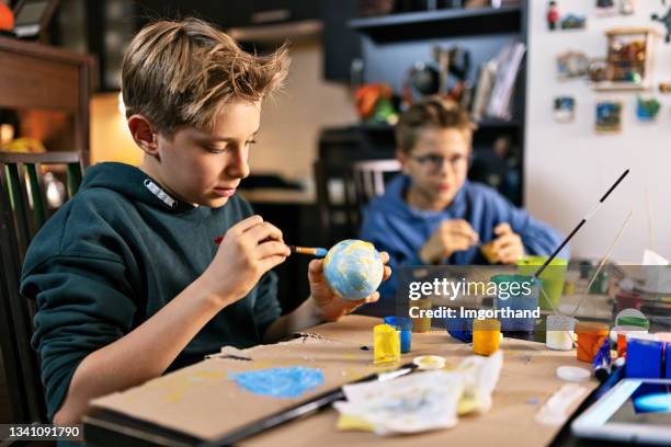 little boys making solar system model at home - kunstnijverheid stockfoto's en -beelden