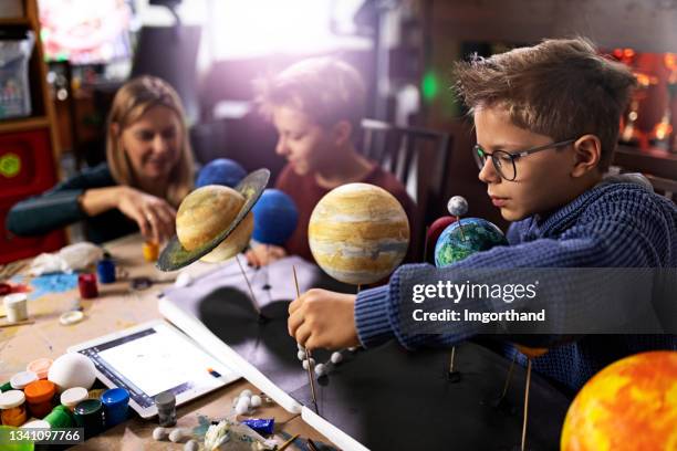 mother helping sons to create a solar system model at home - preteen models | young nonude teen models imagens e fotografias de stock
