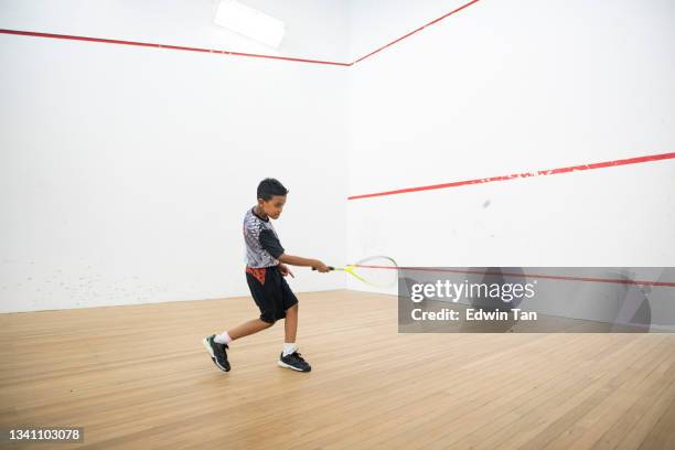 asiatischer malaiischer squashspieler, der während der wochenendroutine alleine auf dem squashplatz trainiert - squash sport stock-fotos und bilder