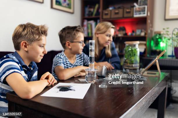 mother teaching kids about water purification and filtration - pure stockfoto's en -beelden