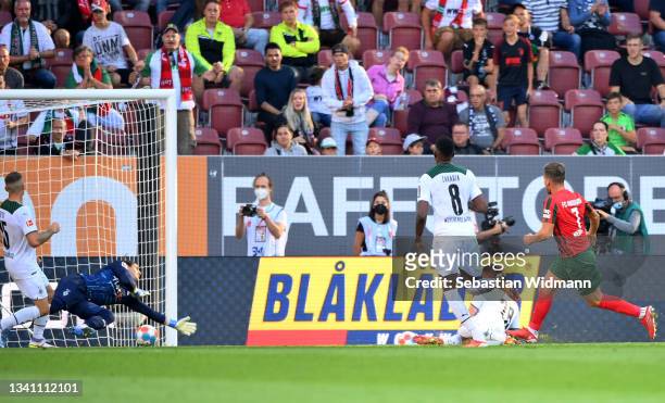Florian Niederlechner of FC Augsburg scores their side's first goal during the Bundesliga match between FC Augsburg and Borussia Mönchengladbach at...