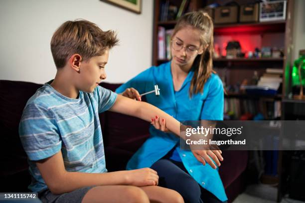 physical therapist examining little boy at home - fisioterapia neurológica imagens e fotografias de stock