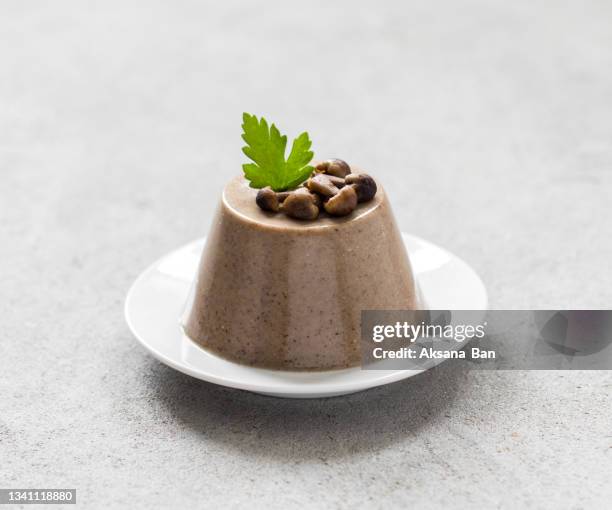 mushroom pudding made of yellow boletus with parsley on a plate on a light gray background - panna cotta photos et images de collection