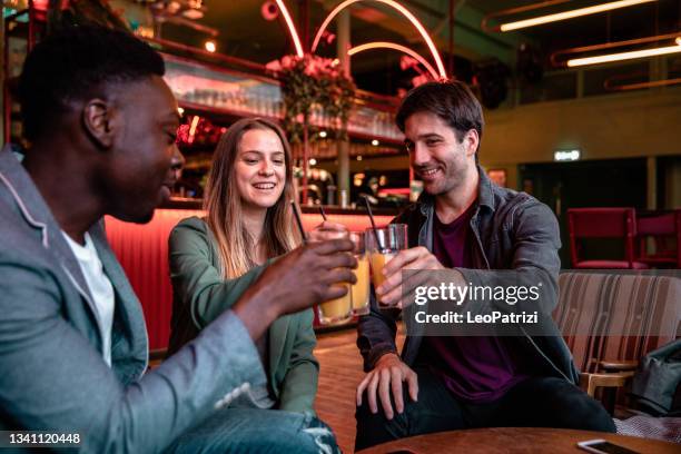 happy group of friends celebrating in a pub - pub stock pictures, royalty-free photos & images