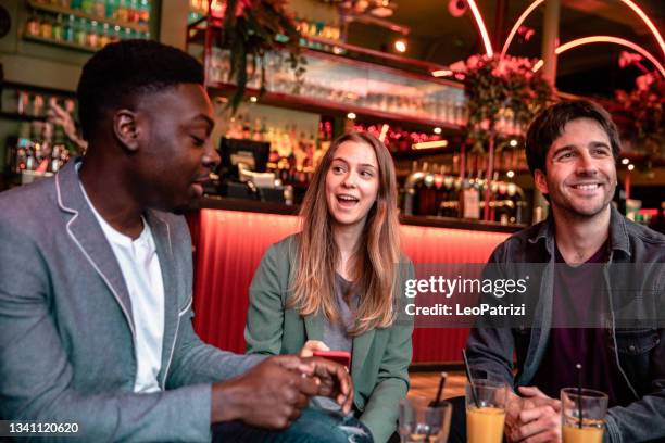 happy group of friends celebrating in a pub - london nightlife stock pictures, royalty-free photos & images