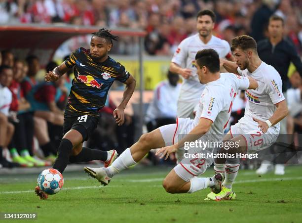 Jorge Mere of 1. FC Köln tackles Christopher Nkunku of RB Leipzig during the Bundesliga match between 1. FC Köln and RB Leipzig at...