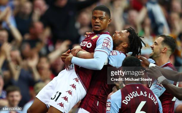 Leon Bailey of Aston Villa is congratulated by Tyrone Mings and teammates after his corner-kick led to their team's second goal, an own goal scored...
