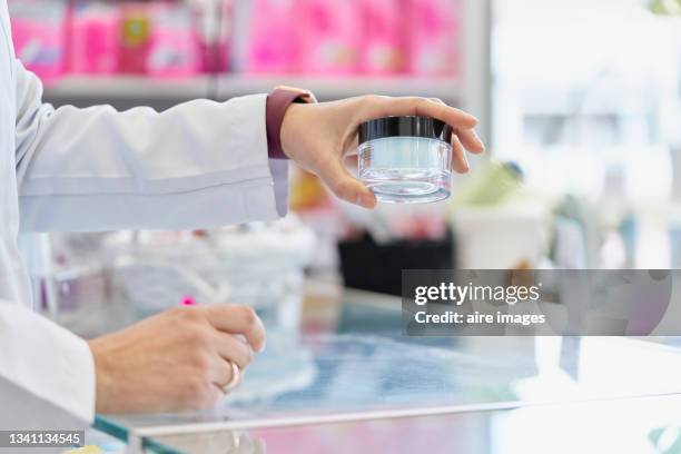 person taking a small glass jar with a black lid with his left hand - checking pockets stock pictures, royalty-free photos & images