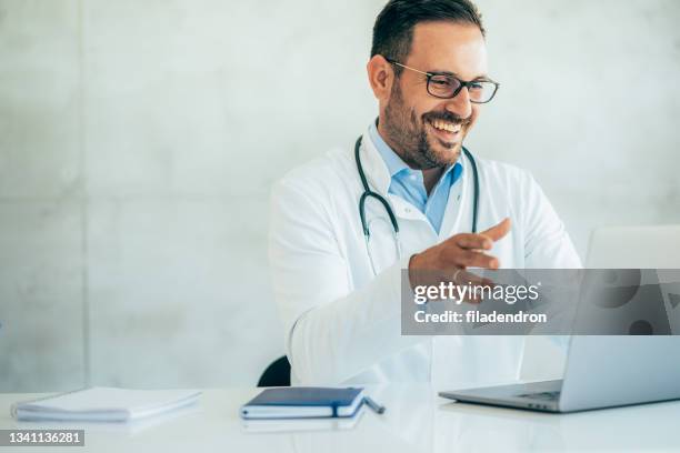 doctor speaks with patient using laptop online - doctor laptop stock pictures, royalty-free photos & images