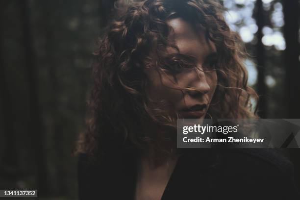 young dramatic woman in the wild forest. nicely fits for book cover - stimmungsvoller himmel stock-fotos und bilder