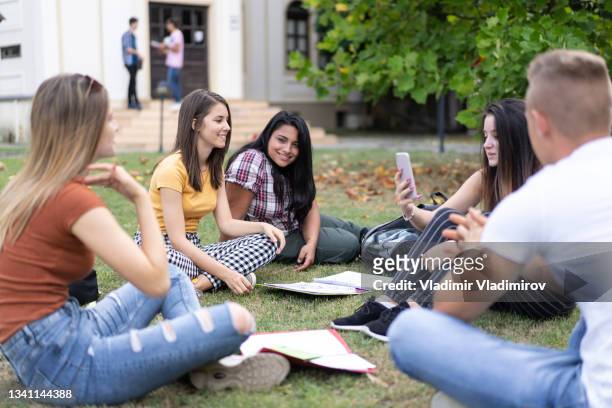 classmates learning in the schoolyard - draped stockfoto's en -beelden