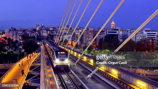the golden horn metro bridge and istanbul cityscape with lights at sunset - medium group of people stock pictures, royalty-free photos & images