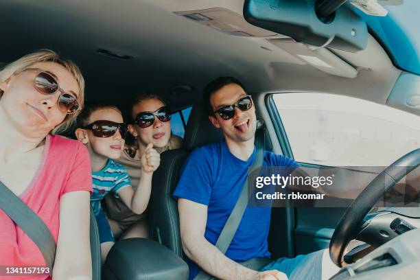 family with beloved children sticking out tongues - family inside car - fotografias e filmes do acervo