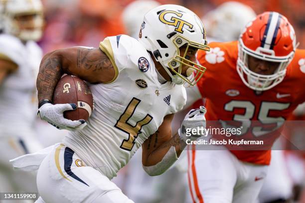 Running back Dontae Smith of the Georgia Tech Yellow Jackets runs with the ball while pursued by defensive end Justin Foster of the Clemson Tigers...