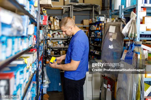 a car mechanic is trying to repair a car failure and looking for car parts. - auto repair shop stockfoto's en -beelden
