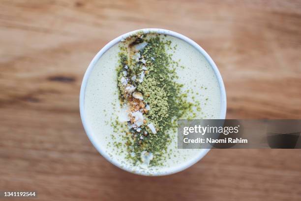 matcha latte with topped with matcha powder and crushed nuts, overhead view - latte art stock pictures, royalty-free photos & images